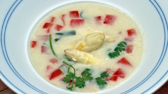 Spargelcremesuppe mit Tomatenwürfeln in einem tiefen Teller serviert. © NDR Foto: Florian Kruck