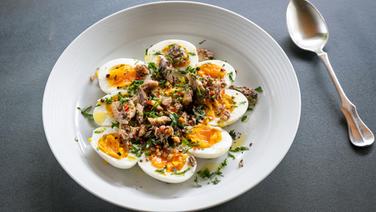 Hard boiled eggs with sardines are served on the dish.  © NDR Photo: Frank von Wieding