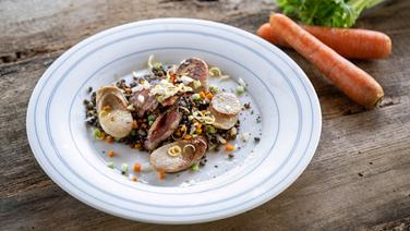 Lentil salad with sausage and bacon served on a plate.  © NDR Photo: Frank von Wieding