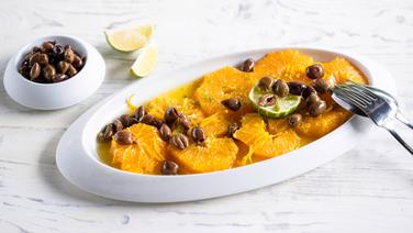 Orangensalat mit Oliven auf einem länglichen Teller serviert. © NDR Foto: Frank von Wieding