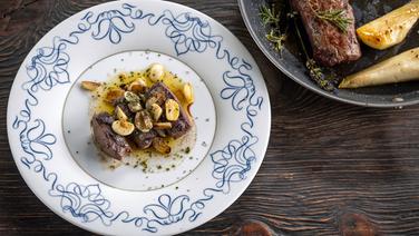 Medallions of saddle of venison with garlic served on a plate.  © NDR Photo: Frank von Wieding