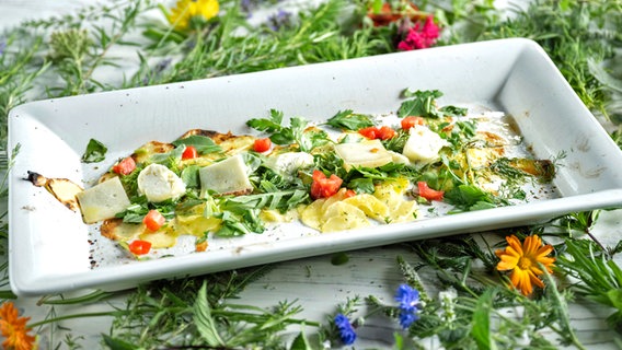 Salat mit gratinierten Kartoffeln, Kräutern und Ziegenkäse auf einem Teller serviert. © NDR Foto: Frank von Wieding