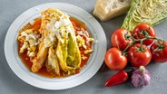 Geschmorter Spitzkohl mit Tomatensoße und Parmesan auf einem Teller serviert. © NDR Foto: Frank von Wieding