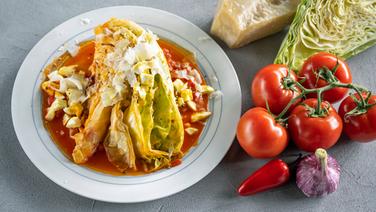 Geschmorter Spitzkohl mit Tomatensoße und Parmesan auf einem Teller serviert. © NDR Foto: Frank von Wieding
