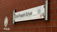 Ein Schild hängt an einer Klinker-Wand. Der Schriftzug auf dem Schild lautet: "Emil-Possehl-Schule". © NDR 