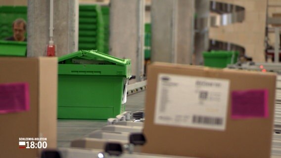 Plastikbehälter und Kartons mit Medikamenten und medizinischem Bedarf rollen über Transportbänder in einem Zentrallager von Asklepios-Kliniken. © NDR 