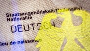 Auf einem Personalausweis spiegelt sich neben dem Schriftzug Staatsangehörigkeit Deutsch ein Bundesadler als Hologramm. © imago Foto: photothek