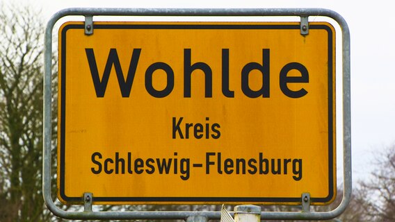 Das gelbe Ortsschild von Wohlde im Kreis Schleswig-Flensburg  