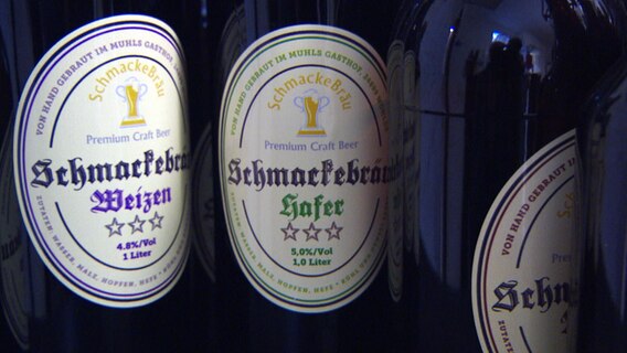 Drei Flaschen Bier mit dem Etikett "Schmackebräu"  