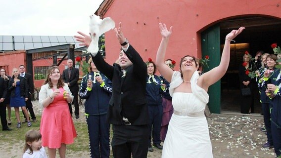 Ein Hochzeitspaar lässt weiße Tauben fliegen. © Andreas Krusche Foto: Andreas Krusche