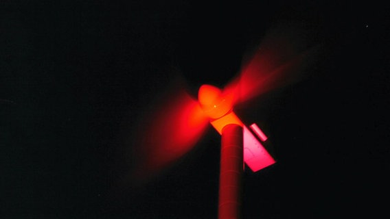 Ein Windrad wird mit rotem Licht angestrahlt. © Peter Vogel Foto: Peter Vogel