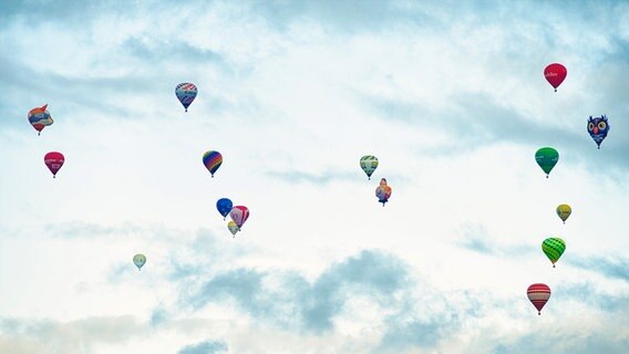 Viele bunte Heißluftballons fliegen in der Luft. © Stephan Baumann Foto: Stephan Baumann