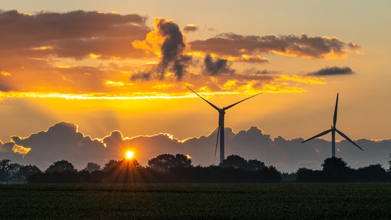 Die aufgehende Sonne hinter Windrädern und Wolken. © Jens Eickmeier Foto: Jens Eickmeier