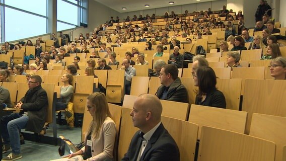 Ein Hörsaal mit vielen Studierenden ist von unten fotografiert. © NDR 