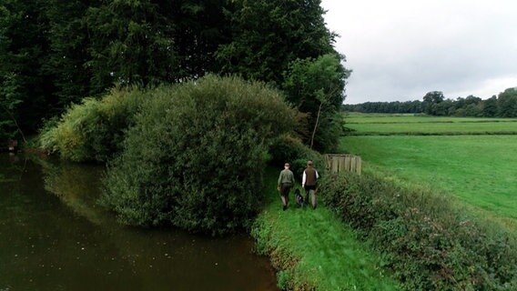 Jäger Azubi Ole Meyer und Jäger Christopher von Dollen (r.) gehen gemeinsam mit einem Jagdhund in den Wald. © NDR 
