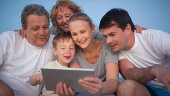 Eine Familie schaut auf ein Tablet © photocase Foto: greycoast