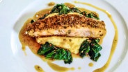 Salmon in teriyaki sauce lies on a plate.  © NDR 