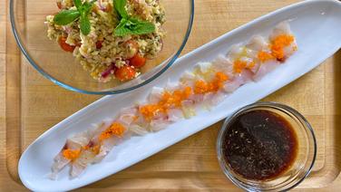 Sashimi vom Wolfsbarsch mit Bulgur-Salat auf einem länglichen Teller und in Schälchen angerichtet. © NDR 