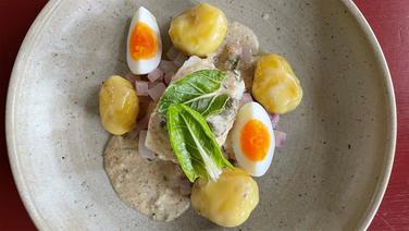 Skrei in Senfsoße mit Butterkartoffeln und Rettich auf einem Teller angerichtet. © NDR 
