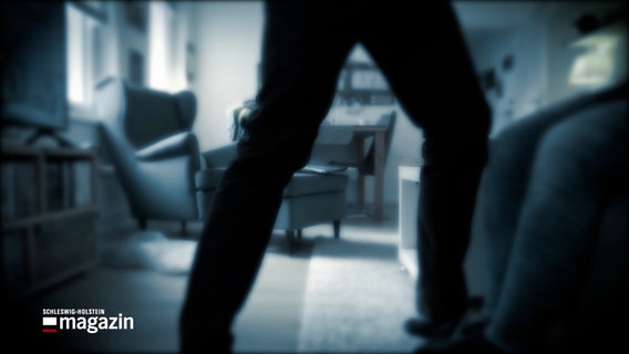 Eine nachgestellte Szene zeigt wie ein Mann eine Frau in einem Wohnzimmer angreift. © NDR 