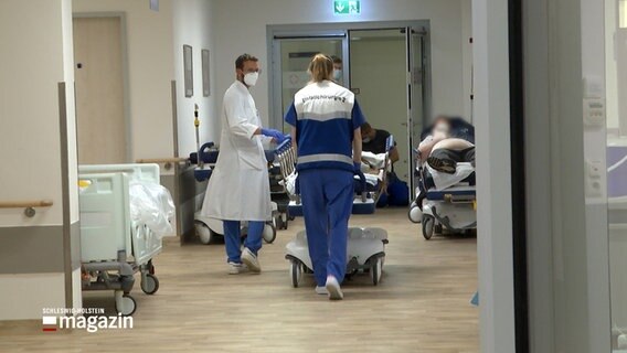 Ein Arzt und eine Sanitäterin gehen durch einen Flur am UKSH in Kiel. © NDR 