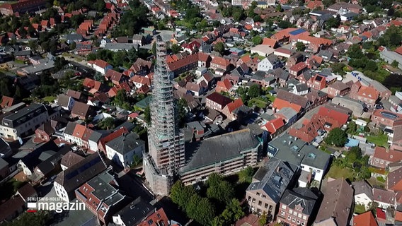 Eine Drohnenaufnahme zeigt den Kirchturm mit Baugerüst in Eiderstedt. © NDR 