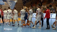 Die Handballmannschaften von VfL Lübeck und HC Saporoschje latschen sich nach dem Spiel ab. © NDR 