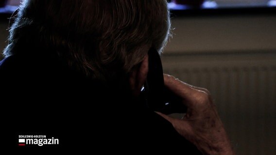 Eine nachgestellte Szene zeigt einen Senioren mit einem Telefon am Ohr im Sessel sitzen. © NDR 