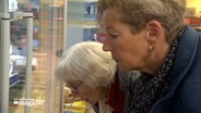 Kümmerin aus Alveslohe, Marita Beine, ist in einem Supermarkt mit einer Seniorin unterwegs. © NDR 