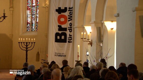 Menschen sitzen in der St. Michaelis Kirche in Eutin beim Auftakt einer Spendenaktion von Brot für die Welt. © NDR 