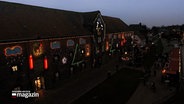 Das historische Tönninger Packhaus erstrahlt in dekorativer Weihnachtsbeleuchtung mit LED-Technik bei Dämmerung. © NDR 