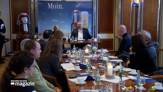 Andreas Tembrockhaus,Geschäftsführer Flensburger Brauerei, sitzt mit geladenen Teilnehmern bei einer Pressekonferenz in einem Konferenzraum der Flensburger Brauerei. © NDR 