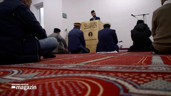 Männer sitzen auf dem Boden einer Moschee in Kiel. © NDR 