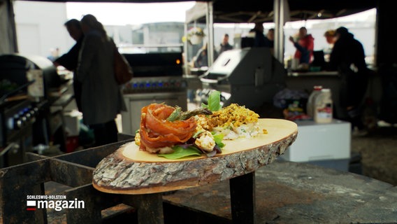Ein Grill-Gericht liegt auf einem Holzbrett bei der Grillmeisterschaft in Neumünster. © NDR 