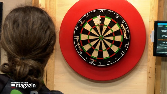 Ein Dartspieler wirft Dartnadeln auf Dartscheibe bei der Landesmeisterschaft Dart in Hattstedt. © NDR 