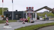 Ein Arbeiter räumt Verkehrsschilder an der Deutsch-Dänischen Grenze weg. © NDR 