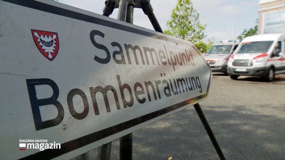 Ein weißes Schild mit dem Schriftzug "Sammelunterkunft Bombenentschärfung" steht vor dem Eingang zur Schwentine Mensa der Fachhochschule Kiel im Kieler Stadtteil Dietrichsdorf bei einer Bombenentschärfung. © NDR 