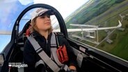 Laura Gärtner sitzt im Cockpit eines Segelfliegers und segelt über Nordfriesland. © NDR 