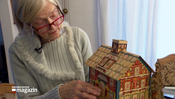 Adventskalender-Sammlerin Angelika Salzwedel hält ein altes Exemplar aus ihrer Sammlung in den Händen. © NDR 