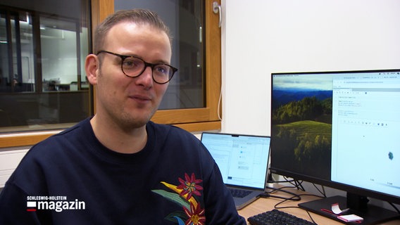 Physikstudent Fabian Gropp sitzt in einem Büro und lächelt dezent in die Kamera bei einem Interview. © NDR 