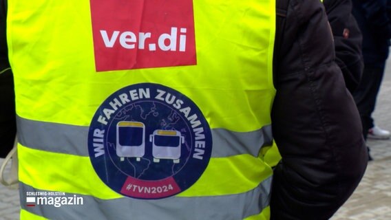 Ein Busfahrer trägt eine grüne Warnweste mit der Aufschrift "Ver.di wir fahren zusammen" während eines Warnstreiks im ÖPNV. © NDR 