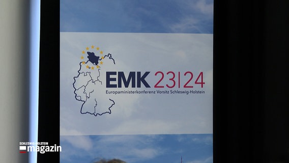 Ein Aufstell-Banner mit dem Schriftzug EMK 23/24 Europaministerkonferenz Vorsitz Schleswig-Holstein steht in einm Raum. © NDR 
