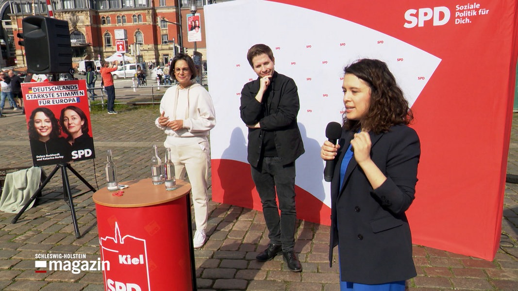 Europaabgeordnete Delara Burkhard spricht bei einer Wahlkampfveranstaltung am Kieler Hauptbahnhof neben Kevin Kühnert und Serpil Medyatli.
