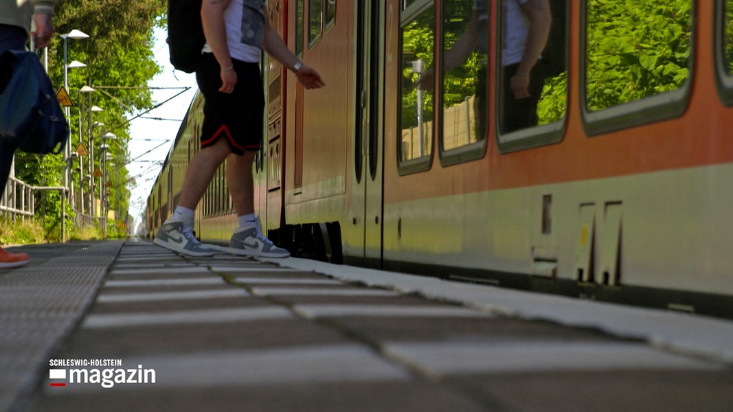 Ein junger Mann steigt in eine Regionalbahn in Brokstedt ein.