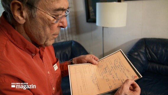 Der Holocaust Überlebende Josef Salomonovic schaut sich ein Dokument an © Screenshot Schleswig-Holstein Magazin 