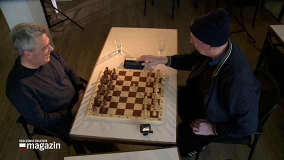 Zwei Personen beginnen eine Schachpartie. © NDR Foto: NDR Screenshots