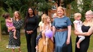 Die Bundesfamilienministerin Lisa Paus (Grüne) und schleswig-holsteinische Familienministerin Aminata Touré (Grüne) stehen mit Kindergartenkindern in einem Garten. © NDR Foto: NDR Screenshots