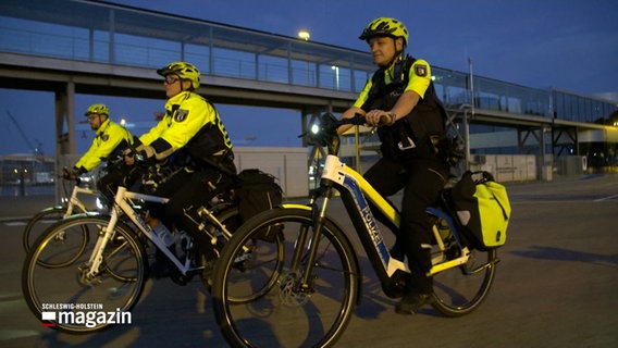 Mitglieder der Kieler Fahrradstaffel fahren am Kieler Hafen entlang © NDR Foto: NDR Screenshots