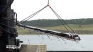 Ein fünf Meter langes Ruderblatt wird bei einer Bergung aus dem Wasser der Trave gehoben © NDR Foto: NDR