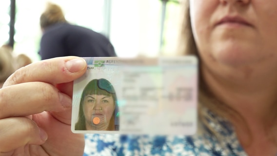 Eine Frau hält ihren Personalausweis in die Kamera © NDR 